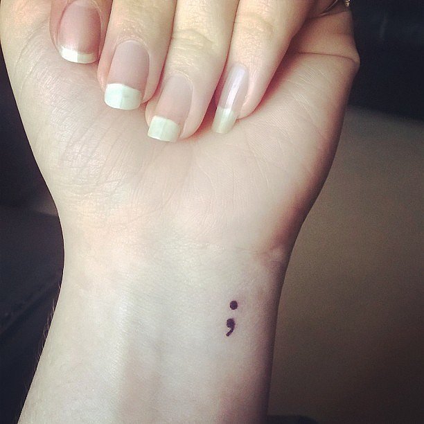 tiny semicolon tattoo on left wrist
