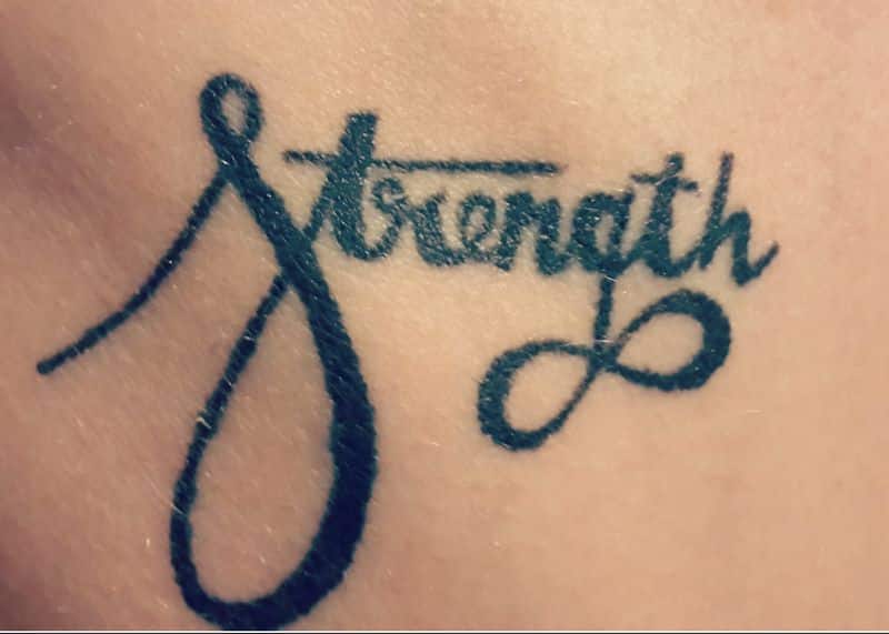 Attractive Black Ink Strength Tattoo
